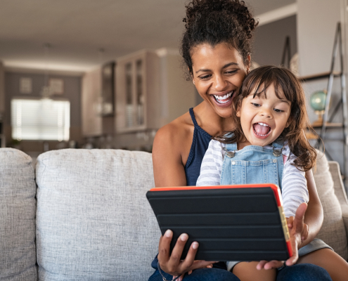 A parent and child at home choosing a broadband service on a tablet